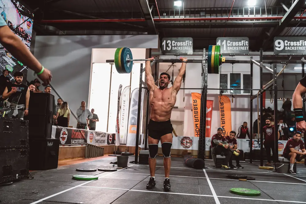 Athlète soulevant une barre pendant un effort intense en compétition