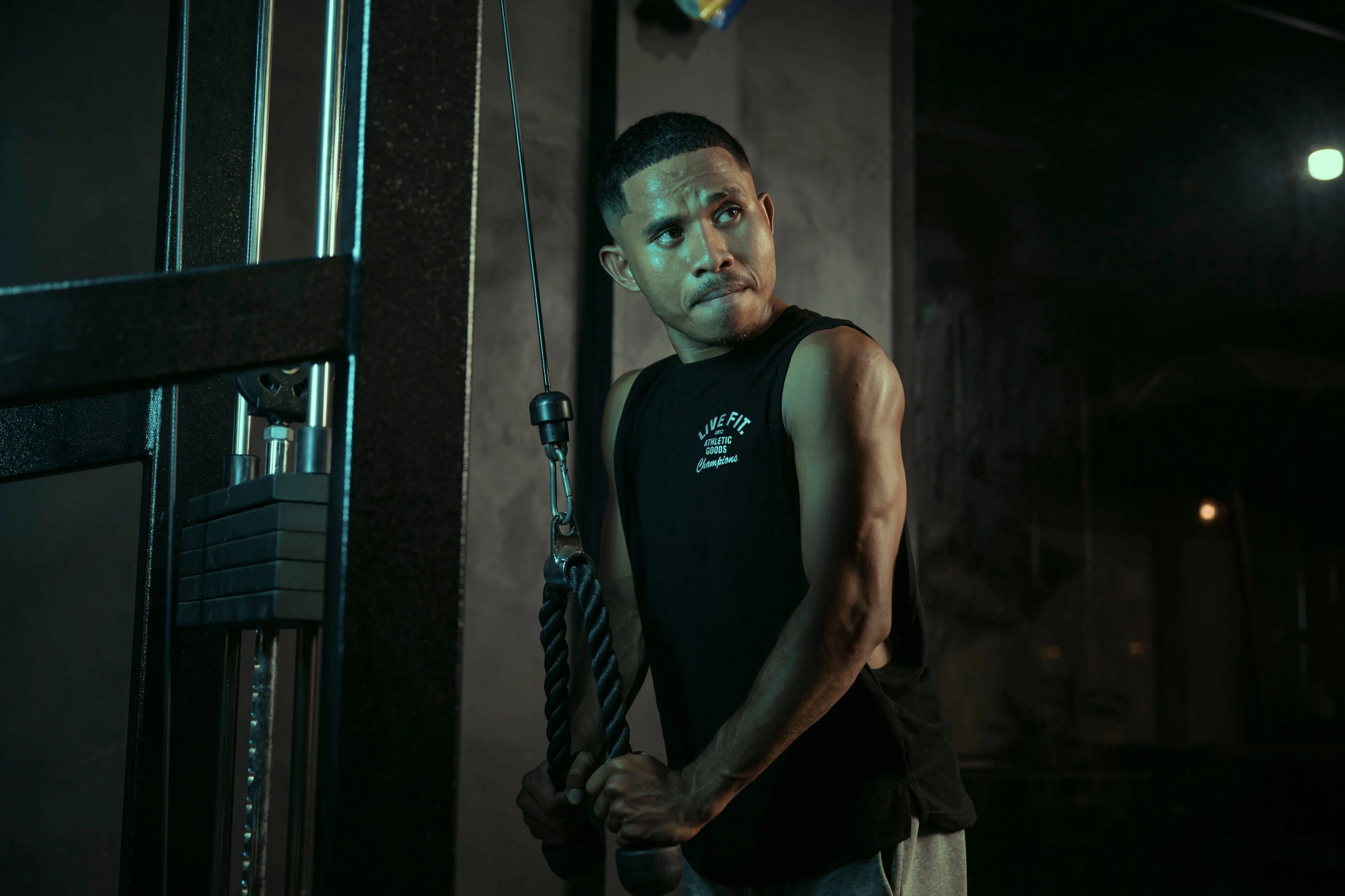 Sportif réalisant un exercice à la poulie en salle de musculation