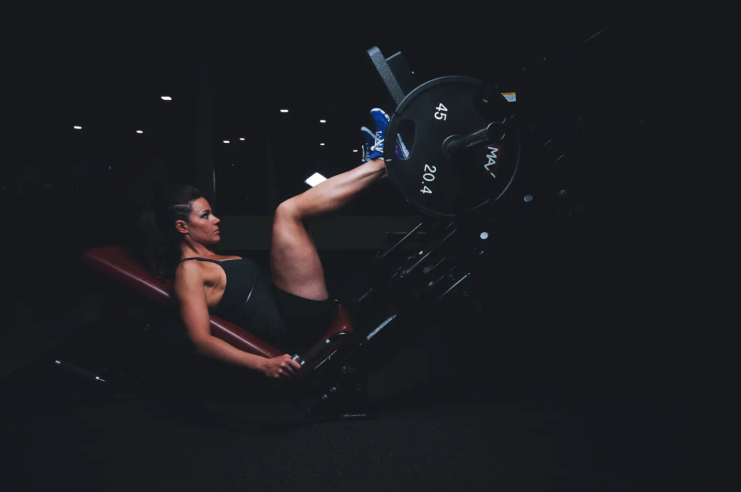 Pratiquante sur une presse à cuisses dans une salle de musculation