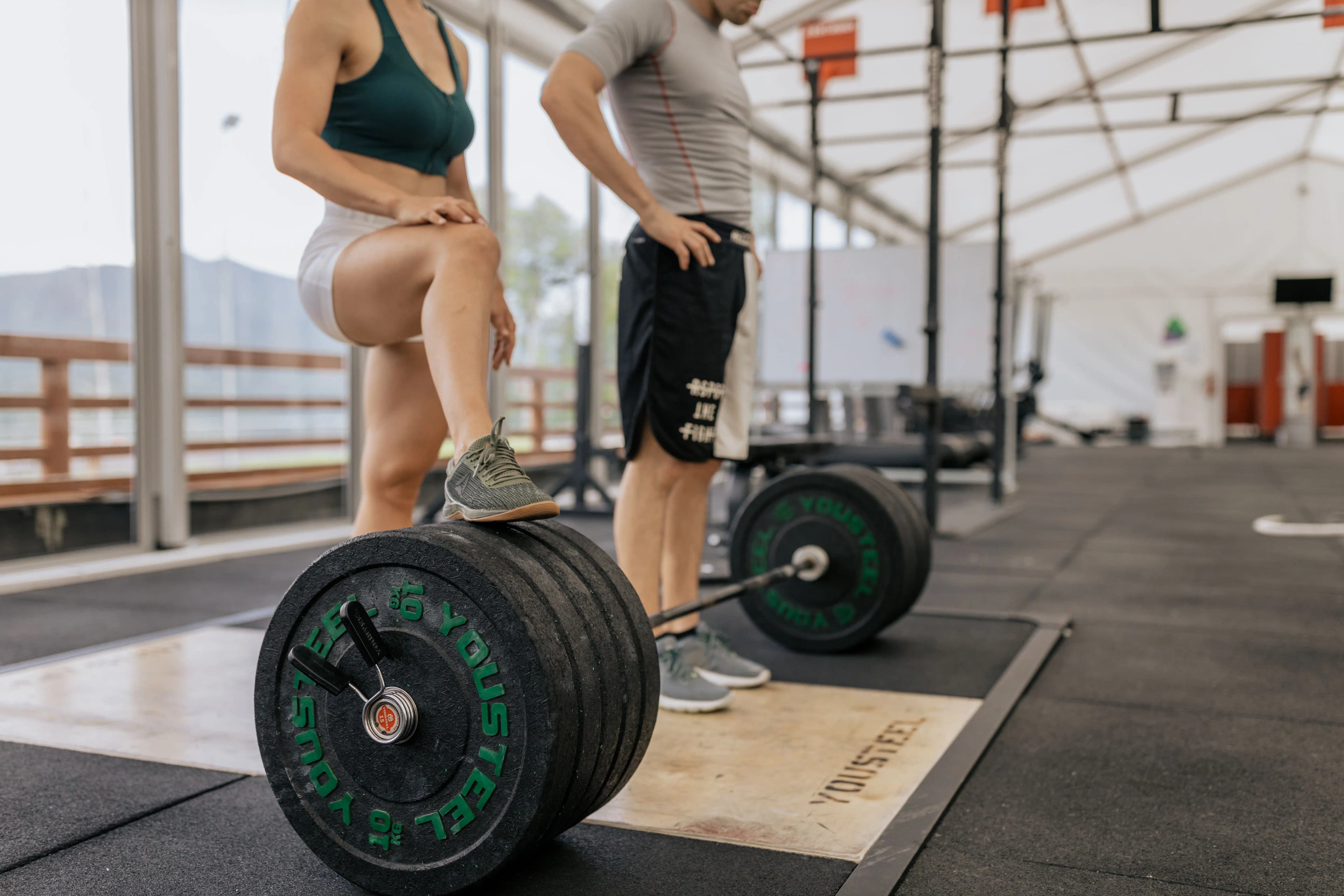 Sportifs organisant leurs séances de musculation autour d’un entraînement avec barre